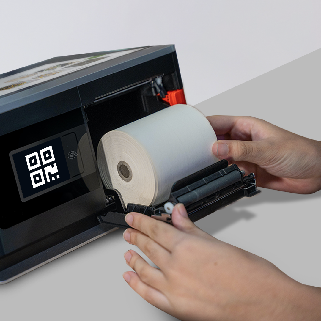 person inserting a roll paper into a point-of-sale terminal
